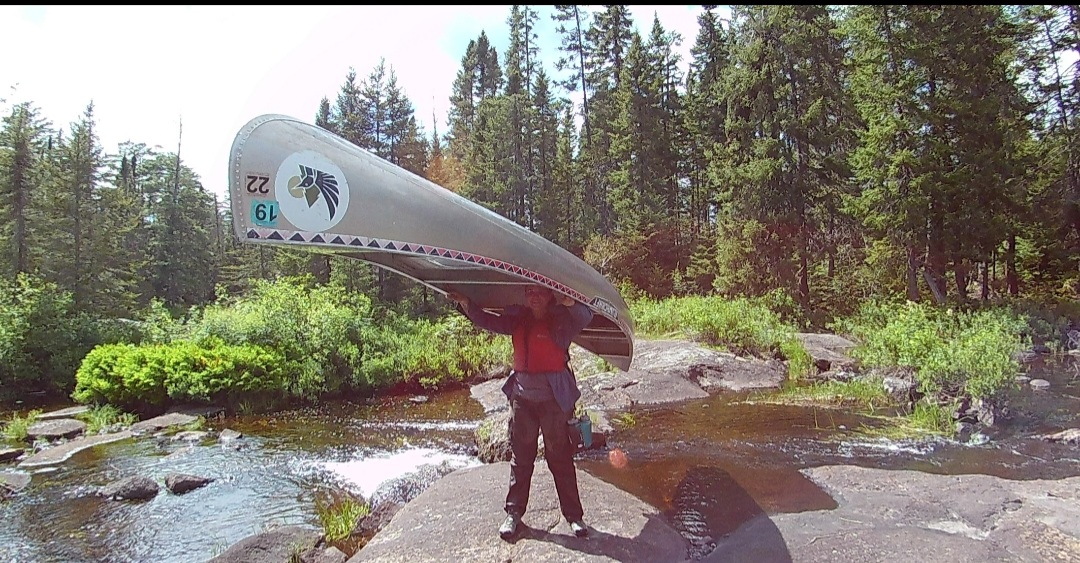 Sarah carries a large canoe upside-down