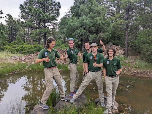 5 Philmont staff members taking picture in pond